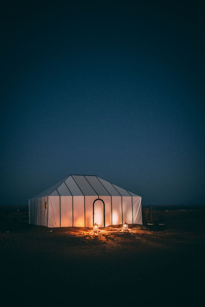 Haima iluminada bajo el cielo estrellado en el campamento del desierto